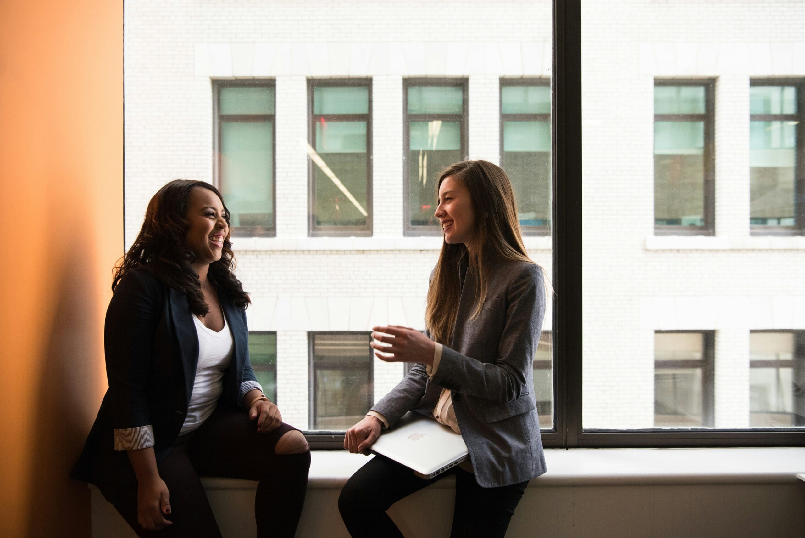 Two women talking by office window